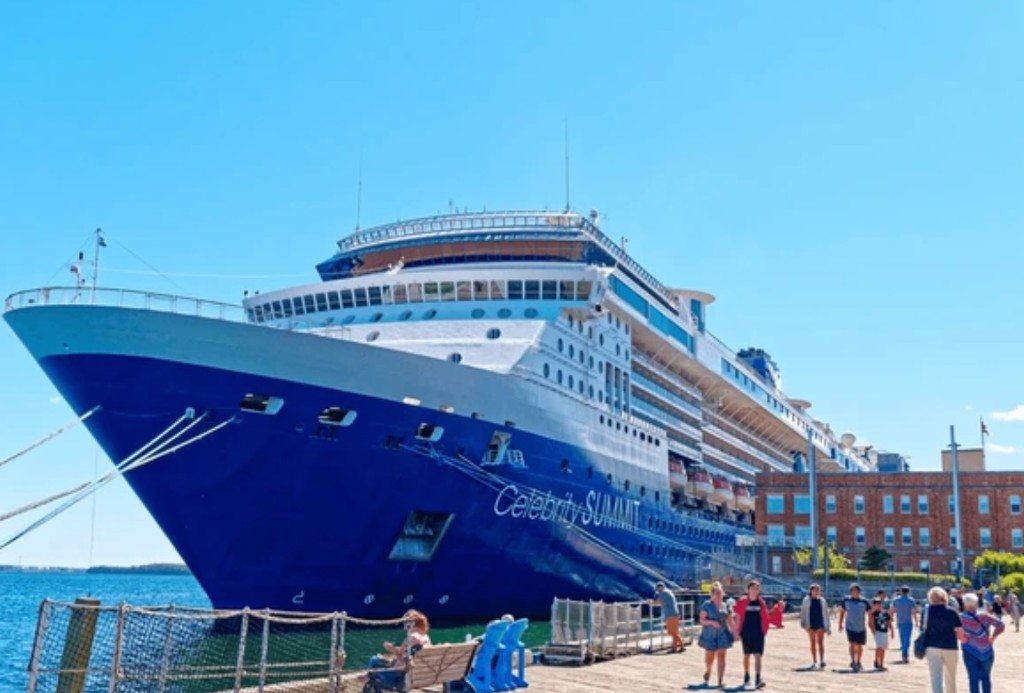 Cruise ship docked at the Halifax waterfront pier with passengers on the boardwalk